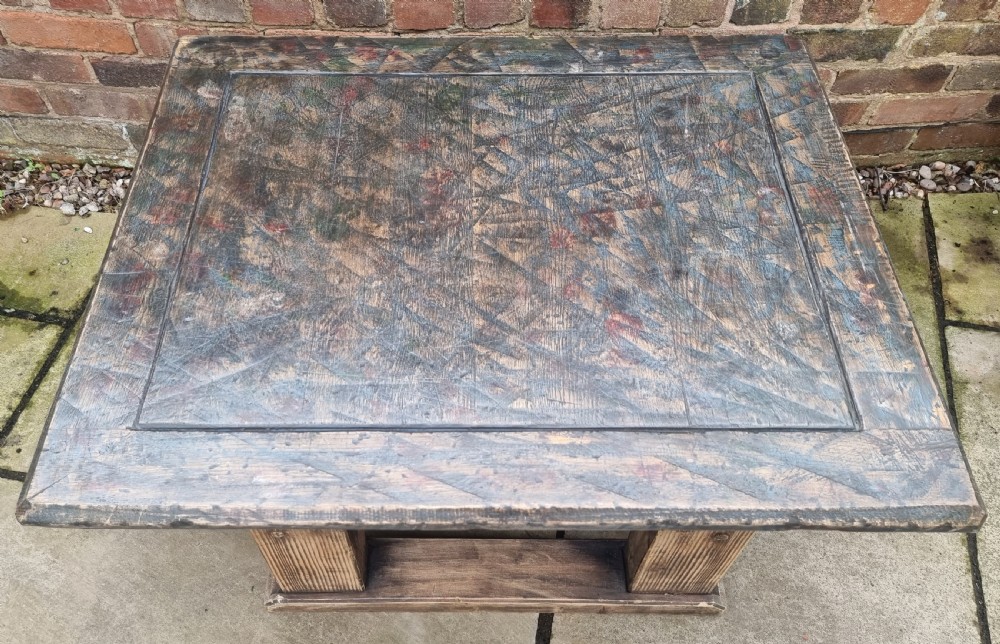 A low square rustic oak coffee table featuring a dark hand-painted geometric top and heavy timber legs. View II