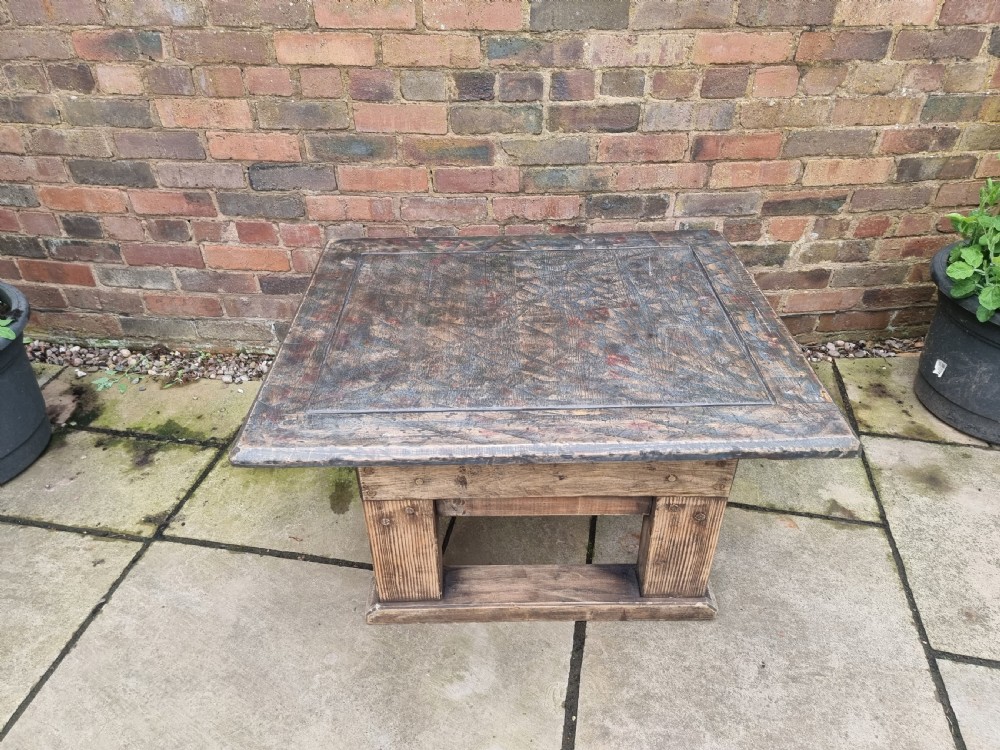 A low square rustic oak coffee table featuring a dark hand-painted geometric top and heavy timber legs. View VII
