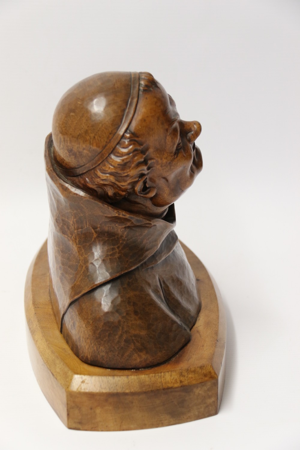 A late 19th-century hand-carved walnut study bust depicting a hooded monk on a moulded wooden base. View V
