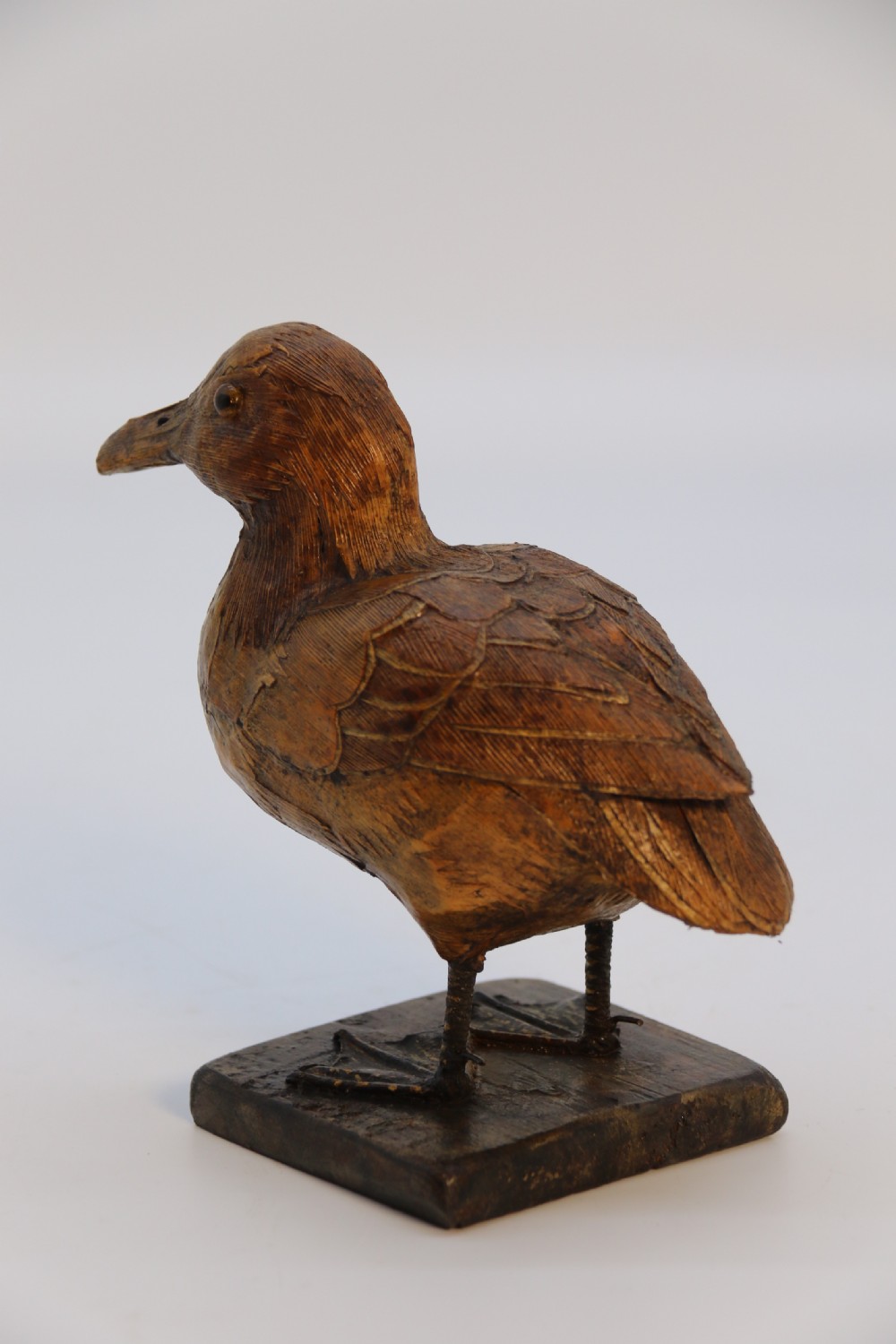 A small folk art duckling sculpture crafted from papier mache and textured straw, mounted on a square wooden base. View II