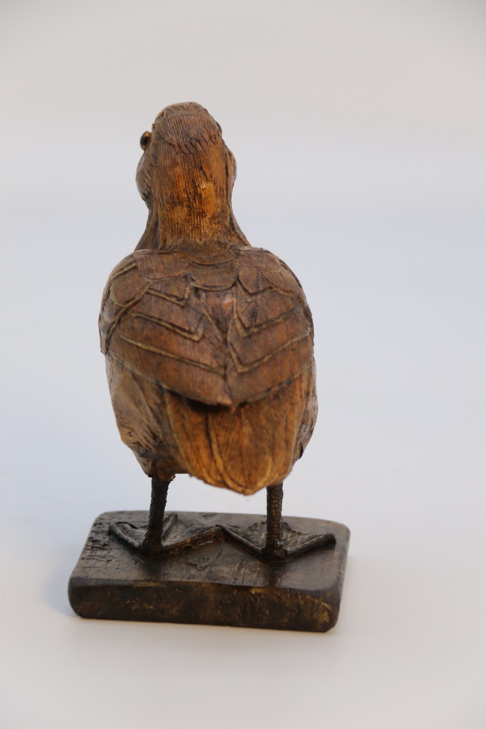 A small folk art duckling sculpture crafted from papier mache and textured straw, mounted on a square wooden base. View III