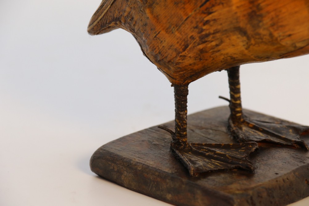 A small folk art duckling sculpture crafted from papier mache and textured straw, mounted on a square wooden base. View XIV