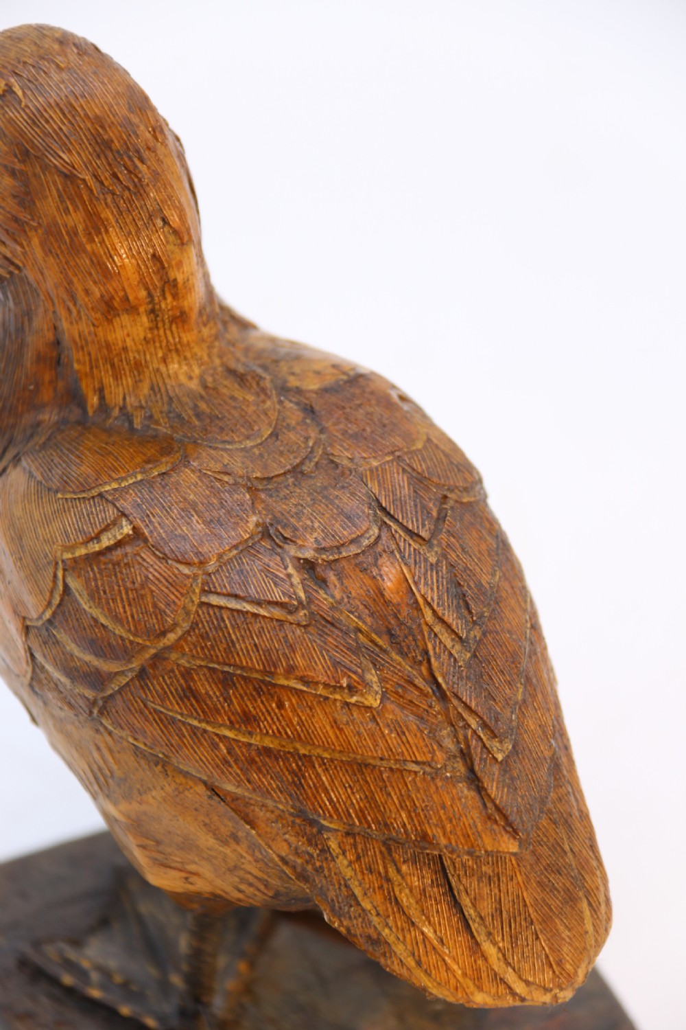 A small folk art duckling sculpture crafted from papier mache and textured straw, mounted on a square wooden base. View XVI