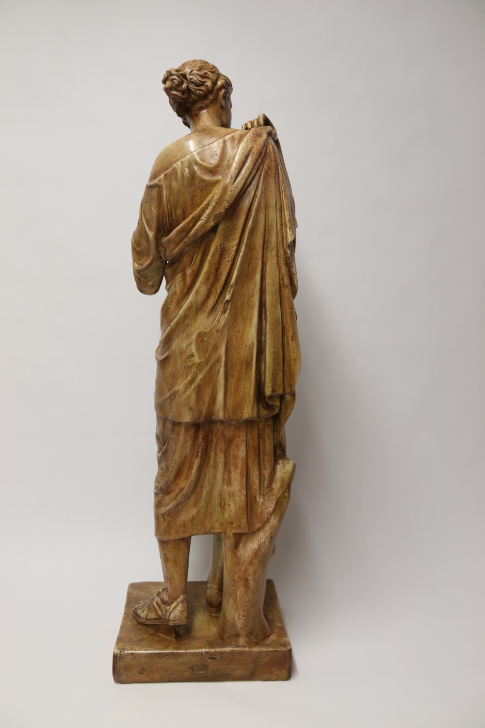 A nineteenth-century Neoclassical sculpture depicting Diana the Huntress draped in classical robes standing on a square base with a warm beige patinated finish. View VI