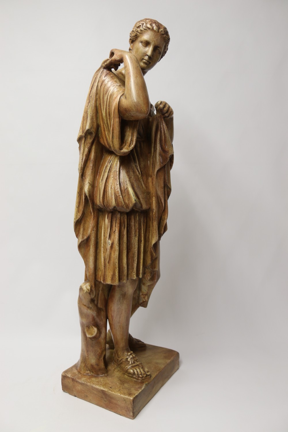 A nineteenth-century Neoclassical sculpture depicting Diana the Huntress draped in classical robes standing on a square base with a warm beige patinated finish. View VII