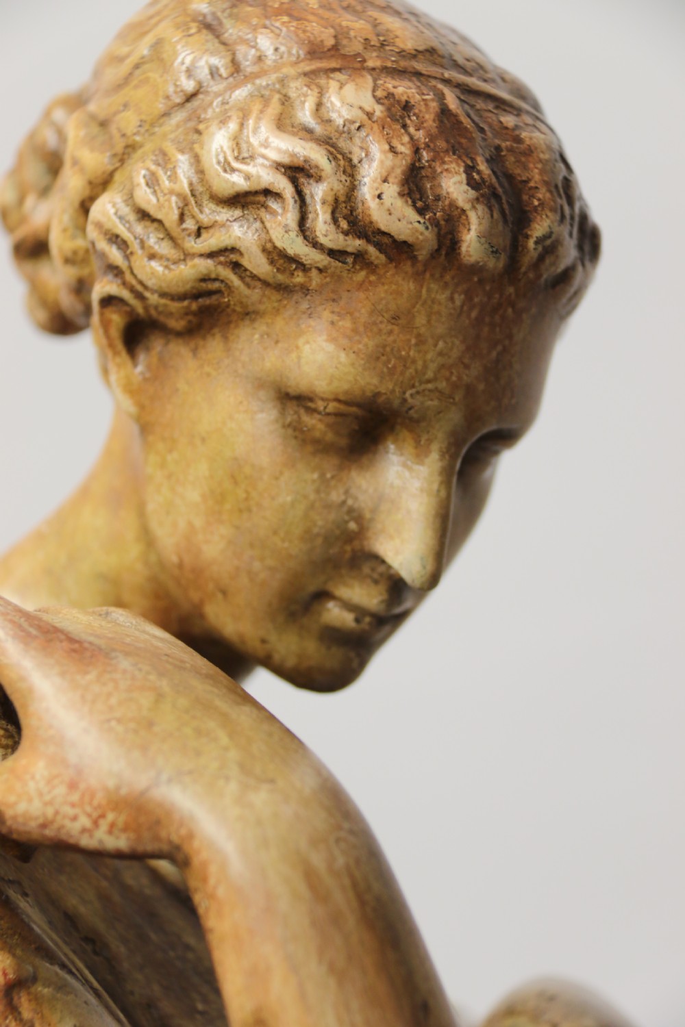 A nineteenth-century Neoclassical sculpture depicting Diana the Huntress draped in classical robes standing on a square base with a warm beige patinated finish. View XII