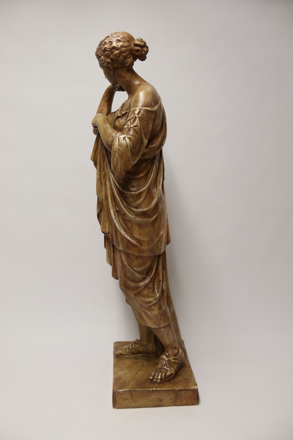 A nineteenth-century Neoclassical sculpture depicting Diana the Huntress draped in classical robes standing on a square base with a warm beige patinated finish. View XXI