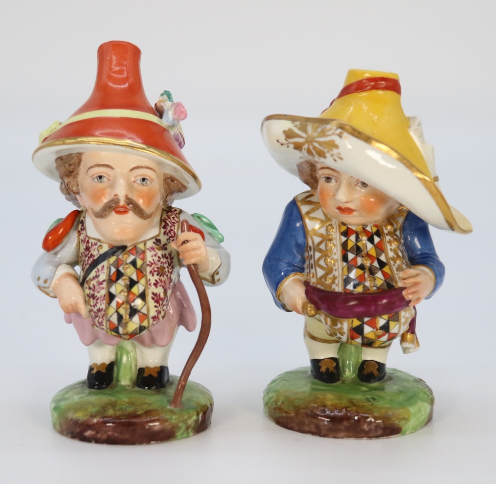 A pair of 19th-century hand-painted Samson porcelain Mansion House dwarf figurines featuring oversized hats and patterned waistcoats.