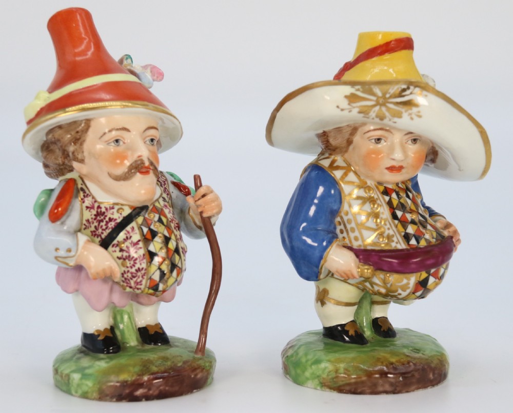 A pair of 19th-century hand-painted Samson porcelain Mansion House dwarf figurines featuring oversized hats and patterned waistcoats. View V