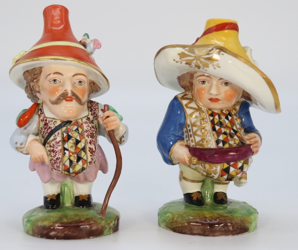 A pair of 19th-century hand-painted Samson porcelain Mansion House dwarf figurines featuring oversized hats and patterned waistcoats. View VI