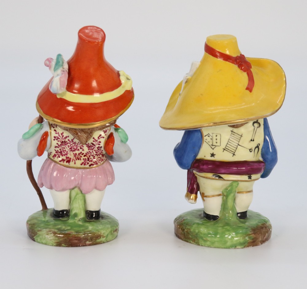 A pair of 19th-century hand-painted Samson porcelain Mansion House dwarf figurines featuring oversized hats and patterned waistcoats. View X