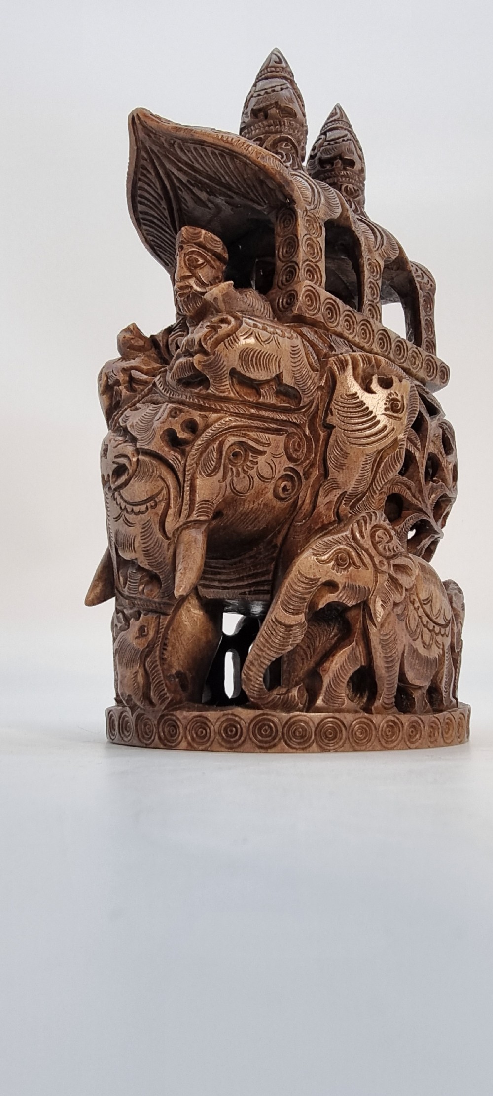 An intricately hand-carved brown soapstone sculpture featuring a ceremonial elephant carrying an elaborate howdah with pierced lattice detailing. View V