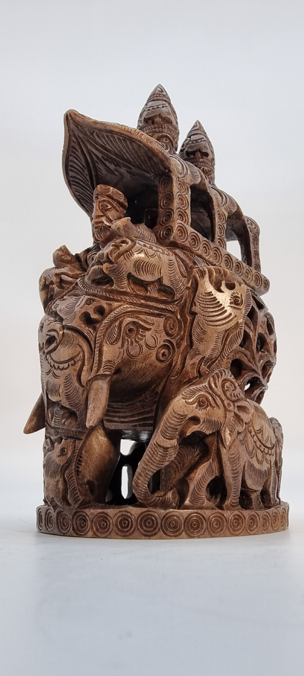 An intricately hand-carved brown soapstone sculpture featuring a ceremonial elephant carrying an elaborate howdah with pierced lattice detailing. View VI