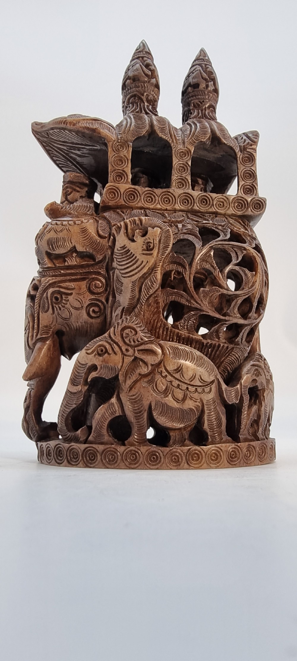 An intricately hand-carved brown soapstone sculpture featuring a ceremonial elephant carrying an elaborate howdah with pierced lattice detailing. View VII