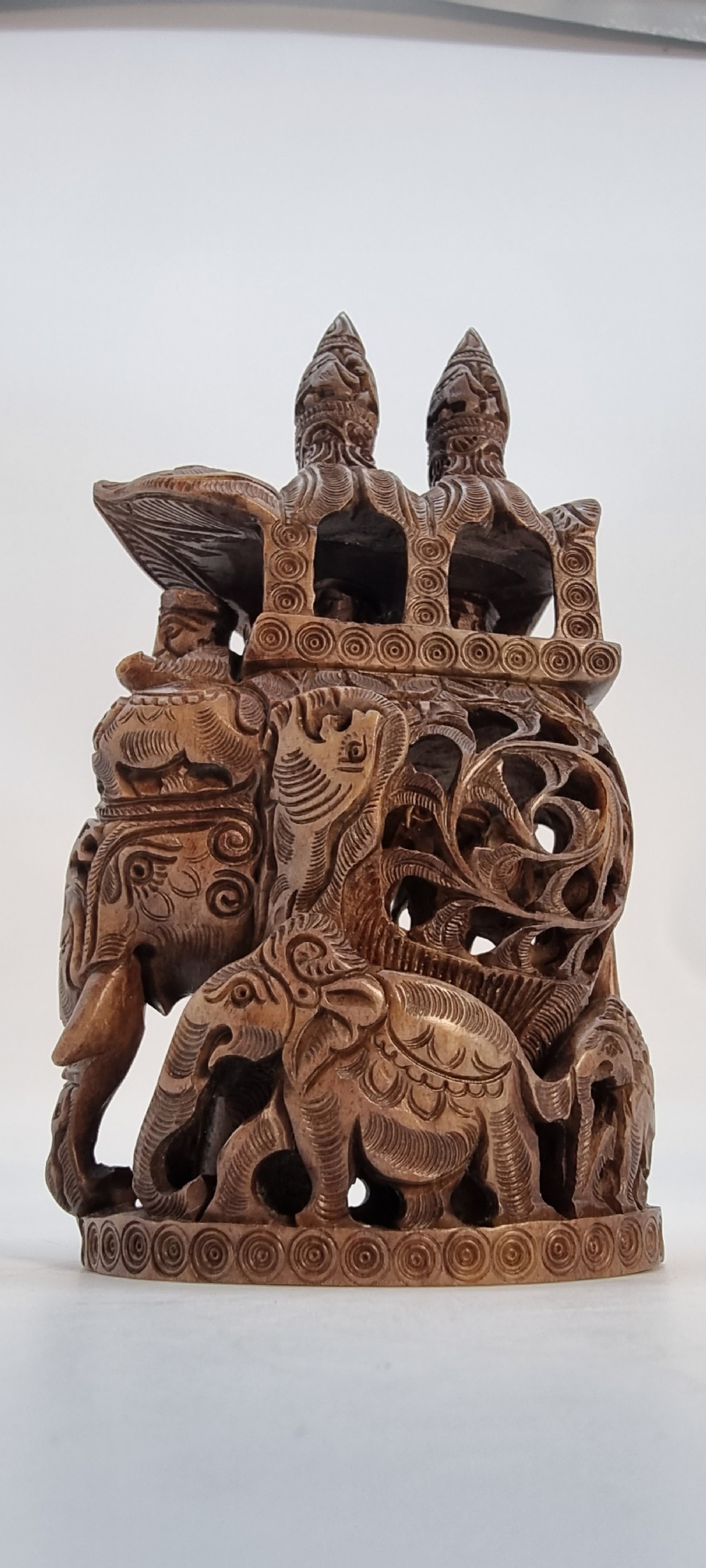 An intricately hand-carved brown soapstone sculpture featuring a ceremonial elephant carrying an elaborate howdah with pierced lattice detailing. View VIII