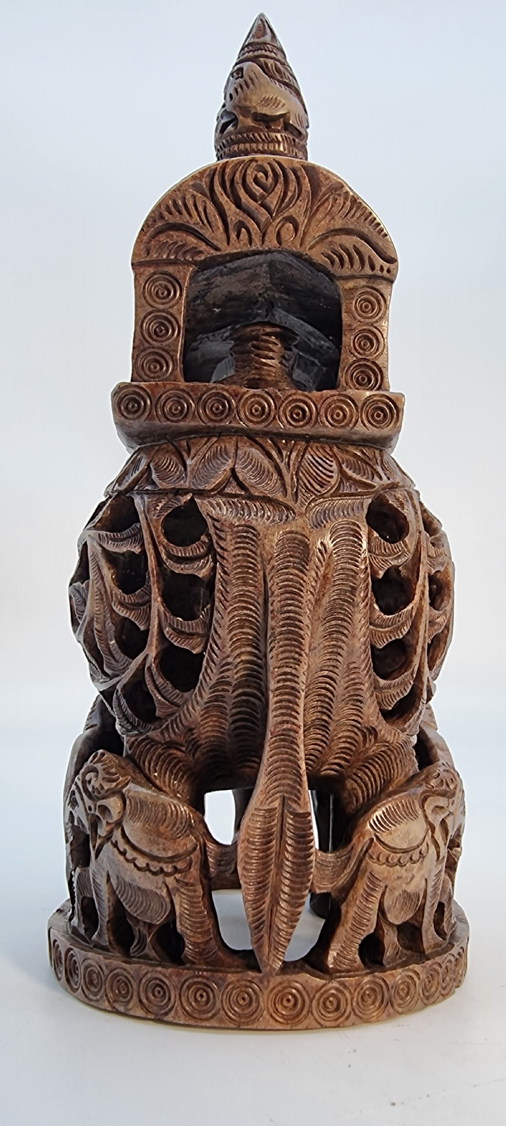 An intricately hand-carved brown soapstone sculpture featuring a ceremonial elephant carrying an elaborate howdah with pierced lattice detailing. View X