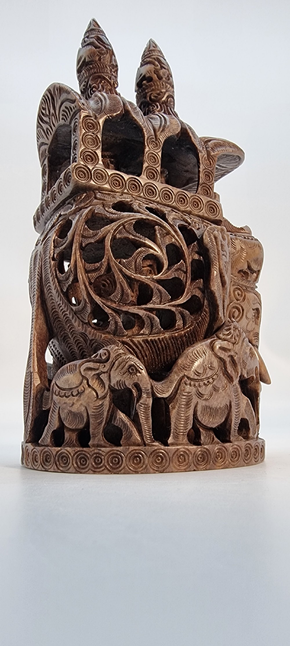 An intricately hand-carved brown soapstone sculpture featuring a ceremonial elephant carrying an elaborate howdah with pierced lattice detailing. View XI