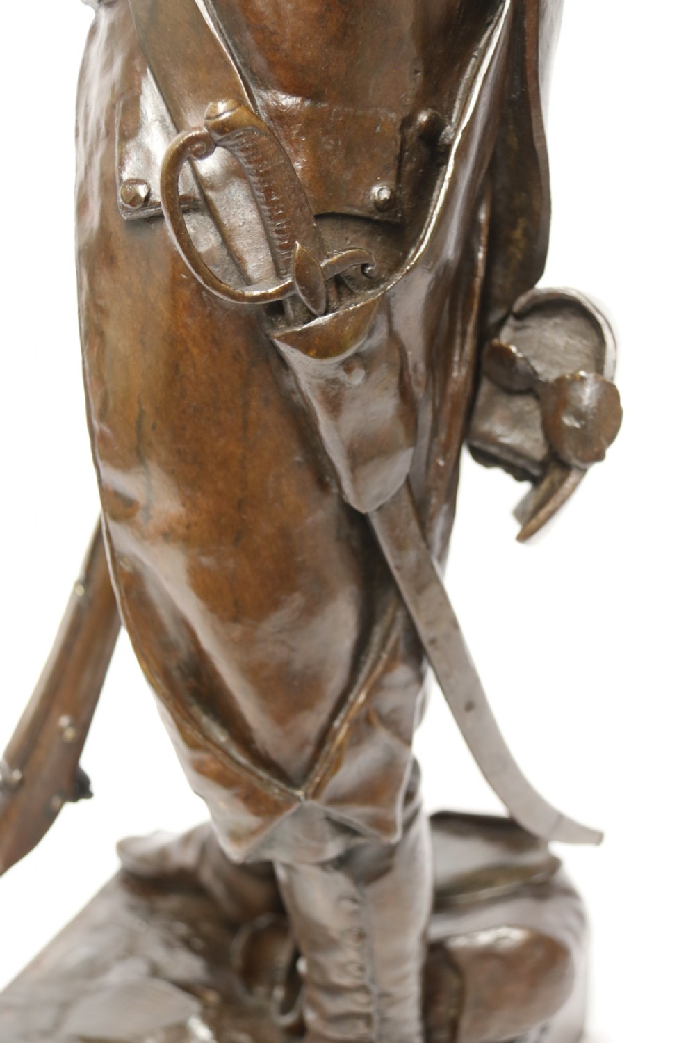 A dark brown patinated bronze sculpture depicting a 1792 French grenadier soldier in full uniform lighting a pipe beside a rifle. View XII