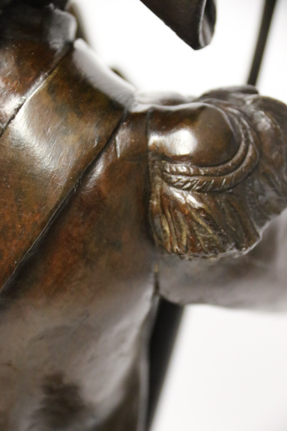 A dark brown patinated bronze sculpture depicting a 1792 French grenadier soldier in full uniform lighting a pipe beside a rifle. View XV