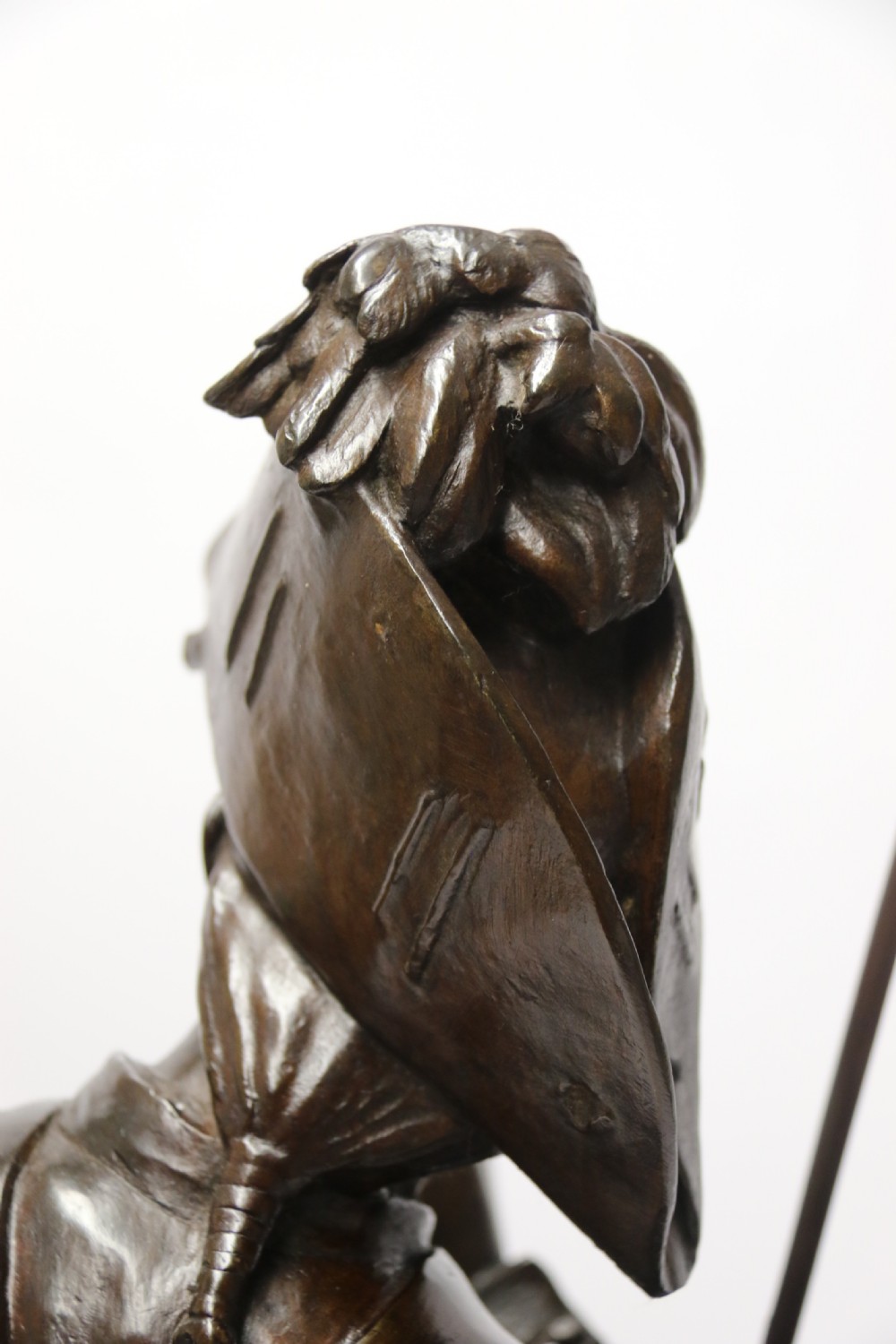 A dark brown patinated bronze sculpture depicting a 1792 French grenadier soldier in full uniform lighting a pipe beside a rifle. View XVIII