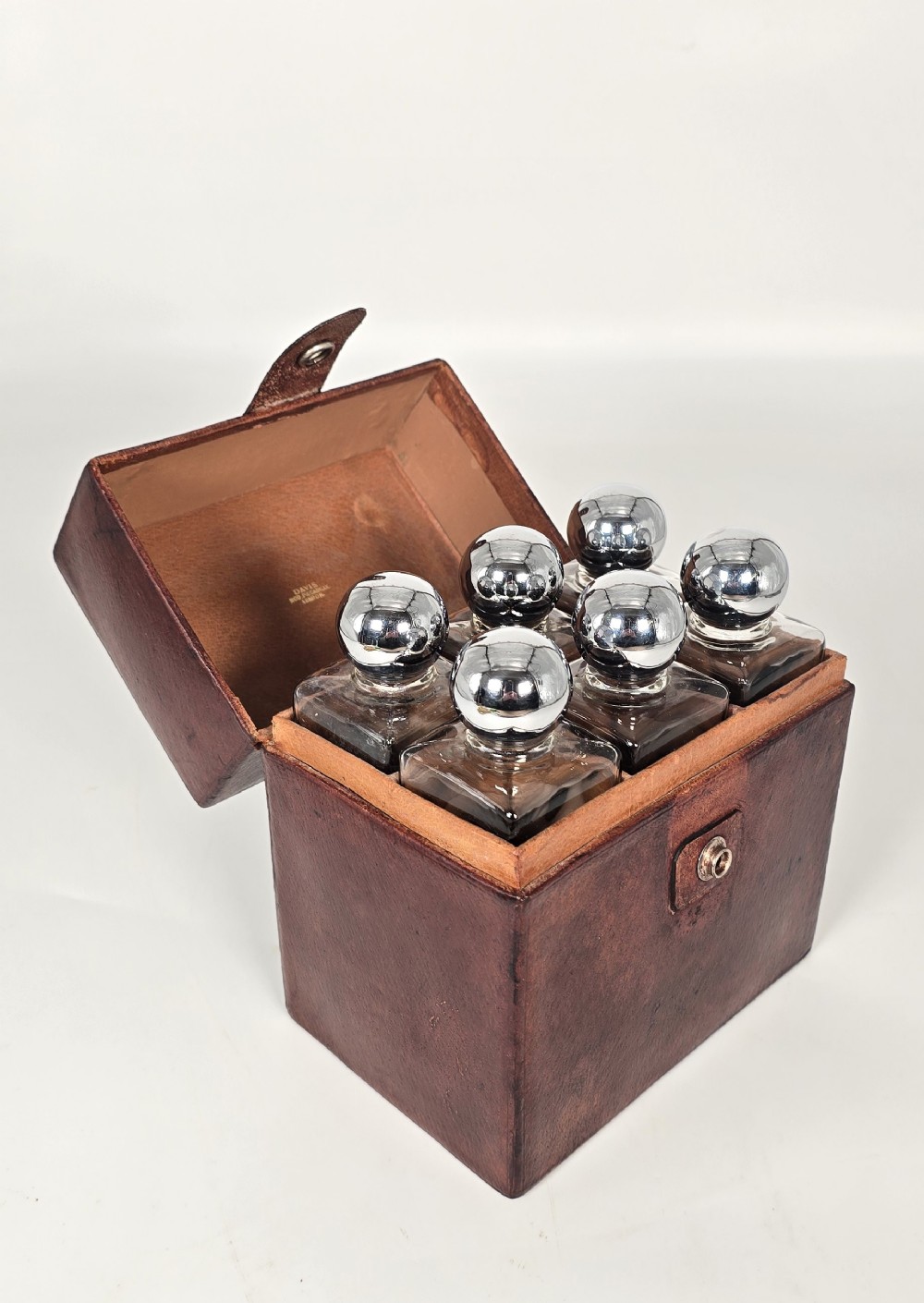 A six bottle spirit decanter set in a fitted leather case originally used when hunting or shooting.