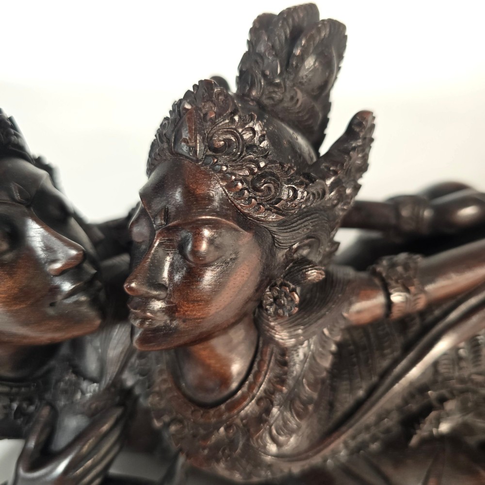 A dark hardwood Balinese carving depicting the reclining figures of Rama and Sita with detailed ornate headdresses and traditional attire. View VIII
