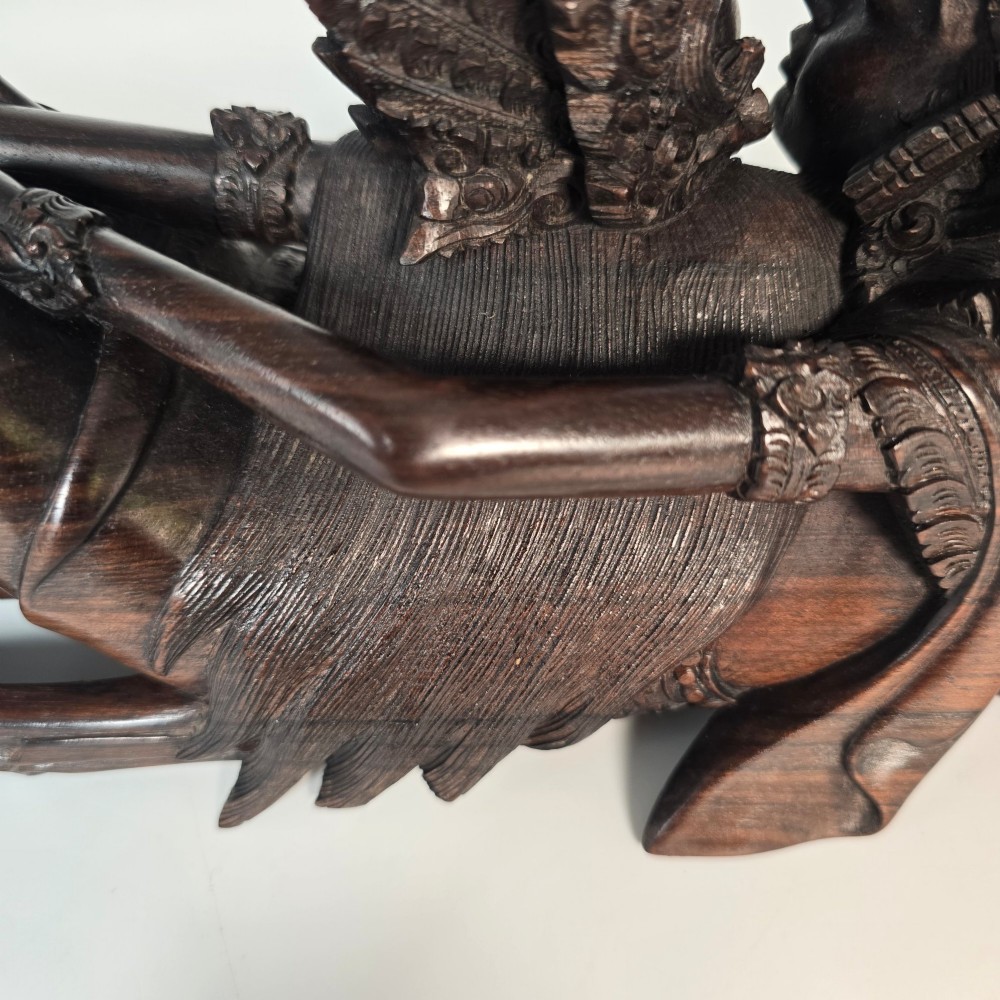 A dark hardwood Balinese carving depicting the reclining figures of Rama and Sita with detailed ornate headdresses and traditional attire. View IX