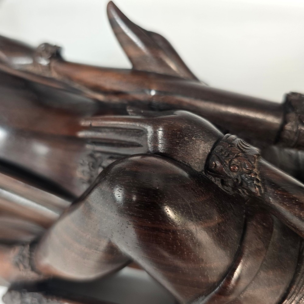 A dark hardwood Balinese carving depicting the reclining figures of Rama and Sita with detailed ornate headdresses and traditional attire. View X