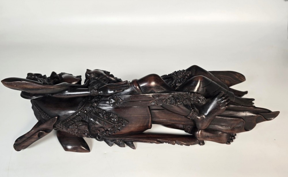 A dark hardwood Balinese carving depicting the reclining figures of Rama and Sita with detailed ornate headdresses and traditional attire. View XIV