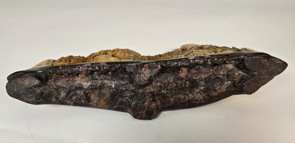 A carved Chinese soapstone continuous landscape featuring mountain peaks, pine trees, and pavilions set upon a fitted dark carved hardwood stand. View XIV