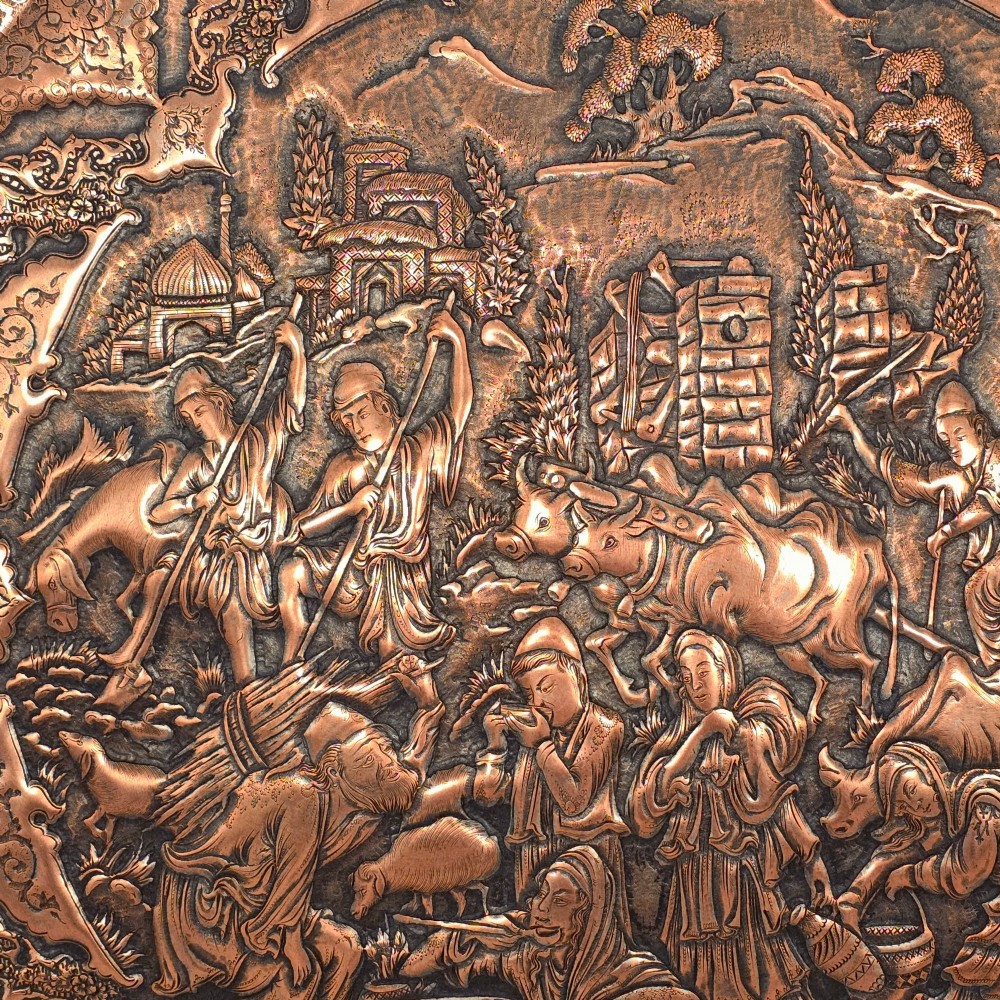 A circular Persian copper charger featuring detailed central repousse relief surrounded by intricate arabesque and paisley borders. View IV