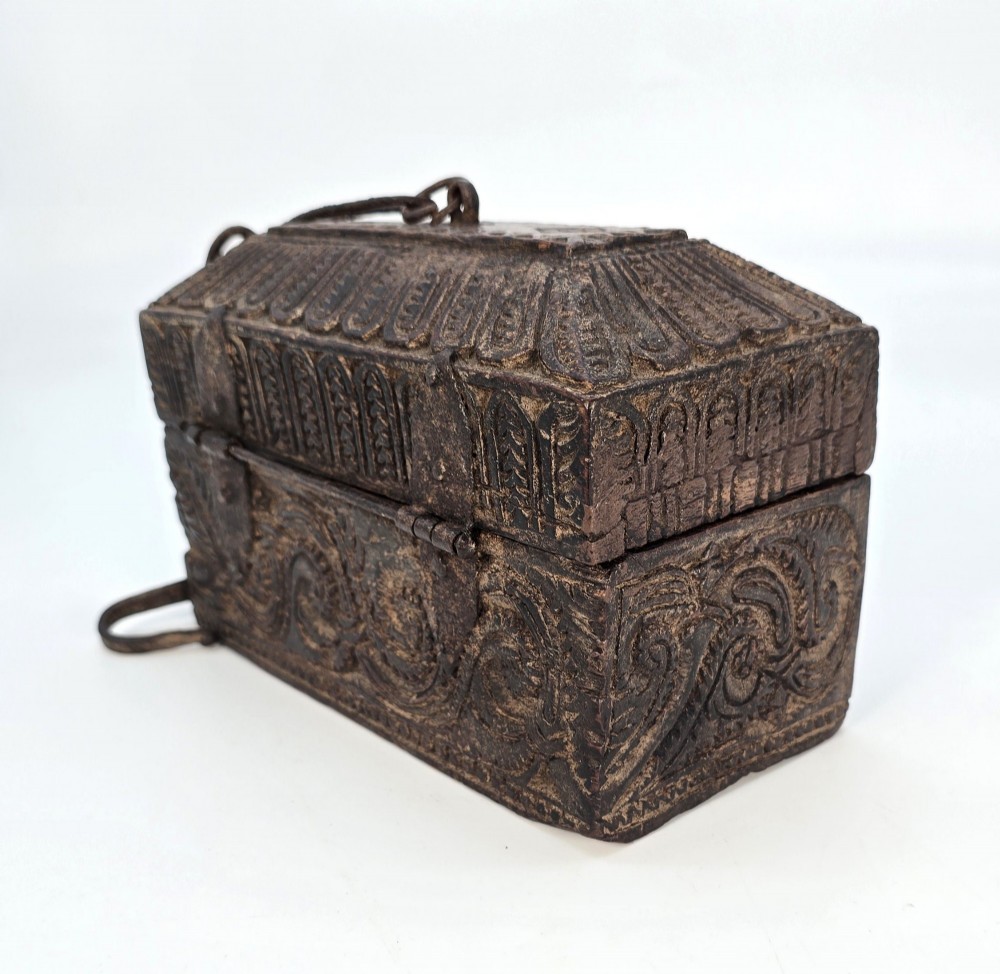 An 18th-century Indian carved dark teak wood spice box featuring a domed lid and attached hand-forged iron hanging chain. View V