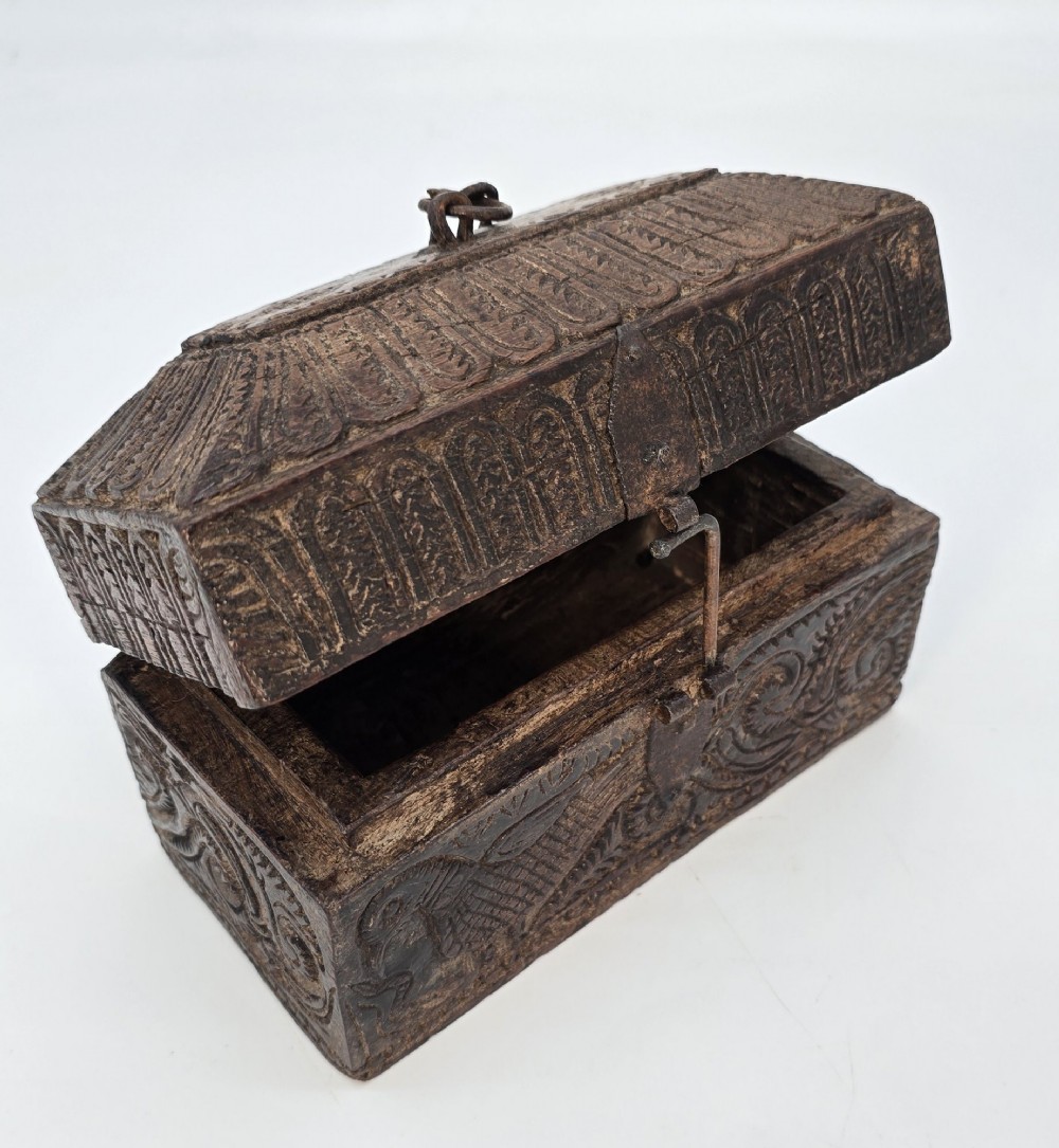 An 18th-century Indian carved dark teak wood spice box featuring a domed lid and attached hand-forged iron hanging chain. View X