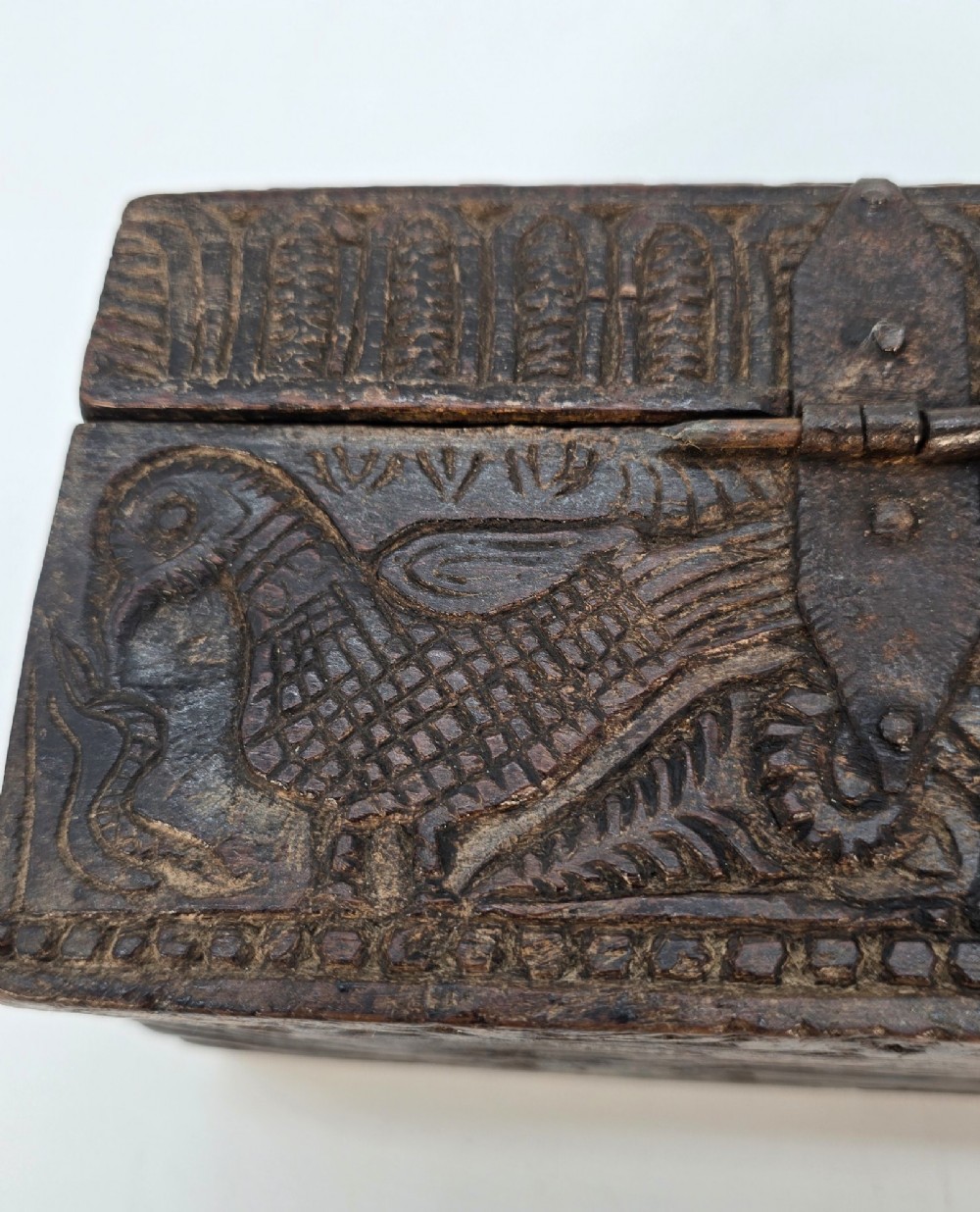 An 18th-century Indian carved dark teak wood spice box featuring a domed lid and attached hand-forged iron hanging chain. View XIV