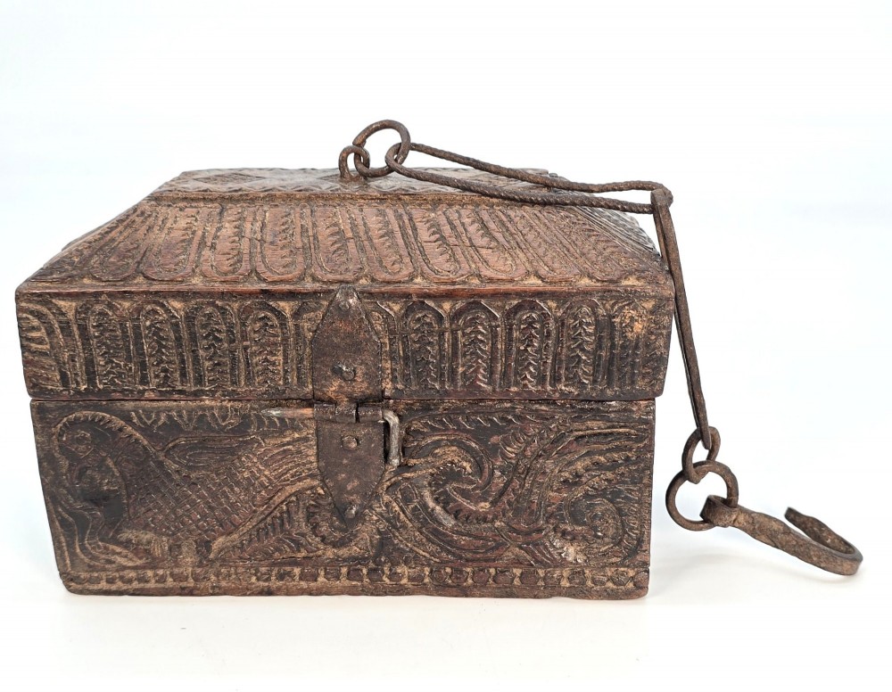 An 18th-century Indian carved dark teak wood spice box featuring a domed lid and attached hand-forged iron hanging chain. View XV
