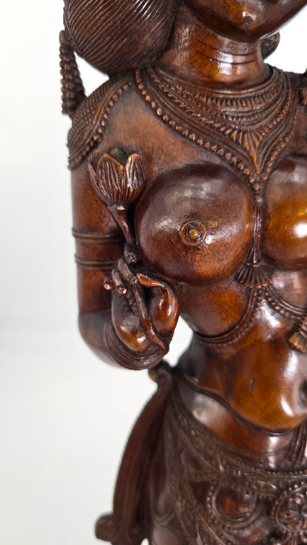 A hand-carved dark wood statue depicting the Goddess Parvati holding infant Ganesha, mounted on an octagonal wooden base. View V