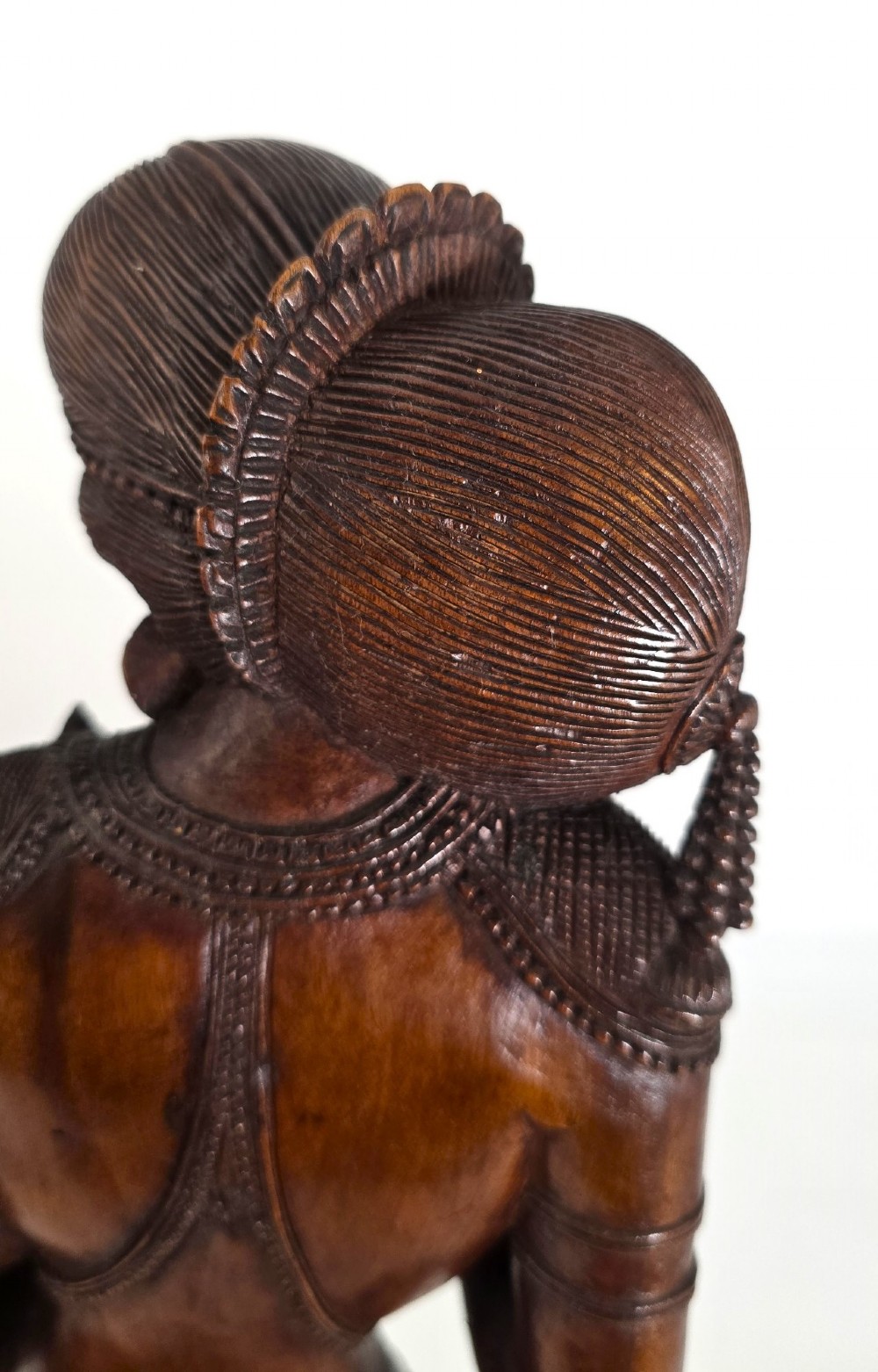 A hand-carved dark wood statue depicting the Goddess Parvati holding infant Ganesha, mounted on an octagonal wooden base. View IX