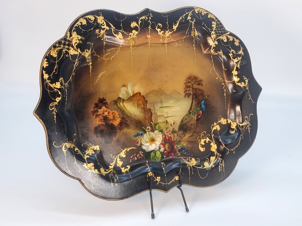 A Victorian shaped papier-mache tray featuring a hand-painted landscape with a castle and peacock surrounded by gold leaf scrollwork on a black background. View II