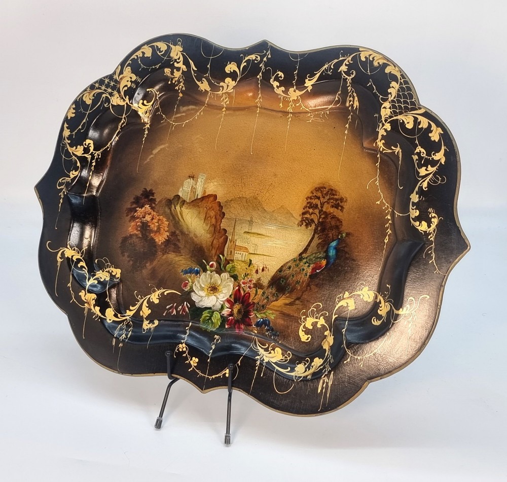 A Victorian shaped papier-mache tray featuring a hand-painted landscape with a castle and peacock surrounded by gold leaf scrollwork on a black background. View III