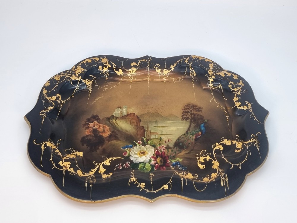 A Victorian shaped papier-mache tray featuring a hand-painted landscape with a castle and peacock surrounded by gold leaf scrollwork on a black background. View XII