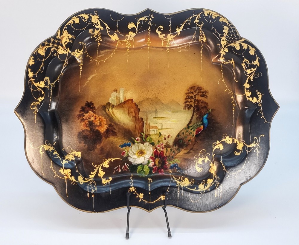 A Victorian shaped papier-mache tray featuring a hand-painted landscape with a castle and peacock surrounded by gold leaf scrollwork on a black background. View XIII