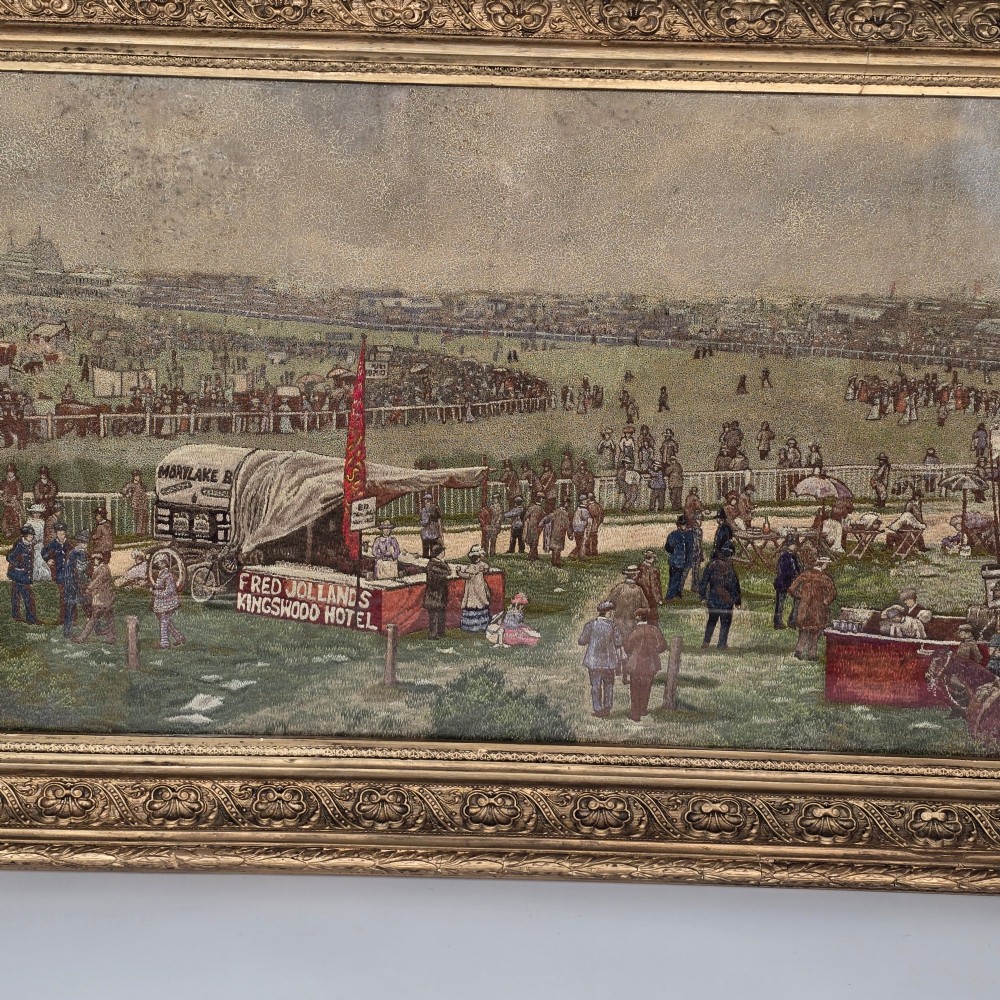 A framed rectangular silk needlework picture depicting figures gathered at the Epsom racecourse within an ornate gilded frame. View X