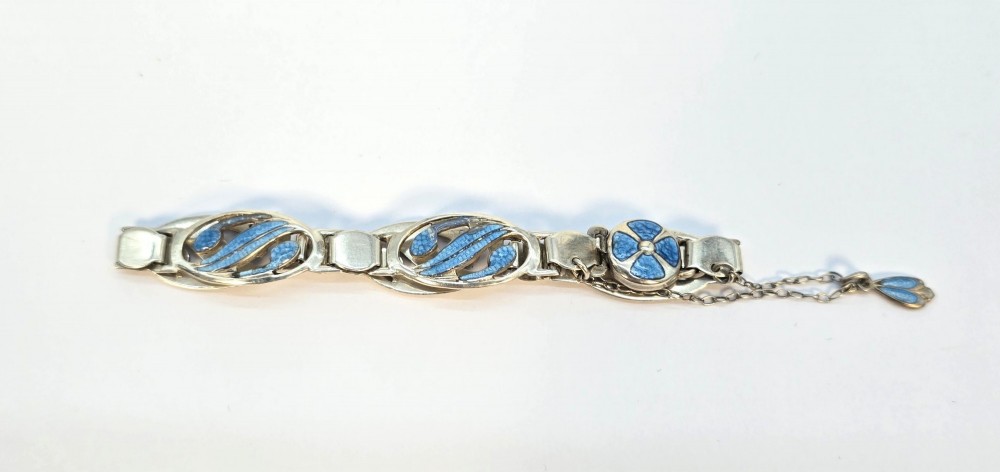 An Edwardian silver link bracelet featuring pierced oval panels filled with light blue enamel and connected by a safety chain. View IV
