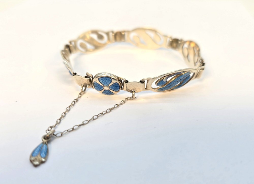 An Edwardian silver link bracelet featuring pierced oval panels filled with light blue enamel and connected by a safety chain. View V