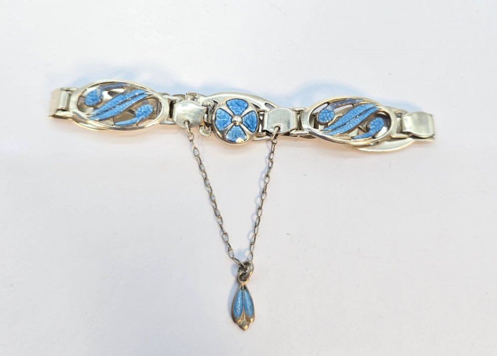 An Edwardian silver link bracelet featuring pierced oval panels filled with light blue enamel and connected by a safety chain. View VIII
