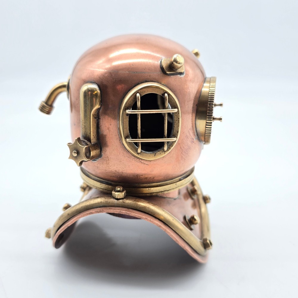A miniature copper and brass deep-sea divers helmet featuring glass viewports, side valves, and brass shoulder plate studs on a plain white background. View III