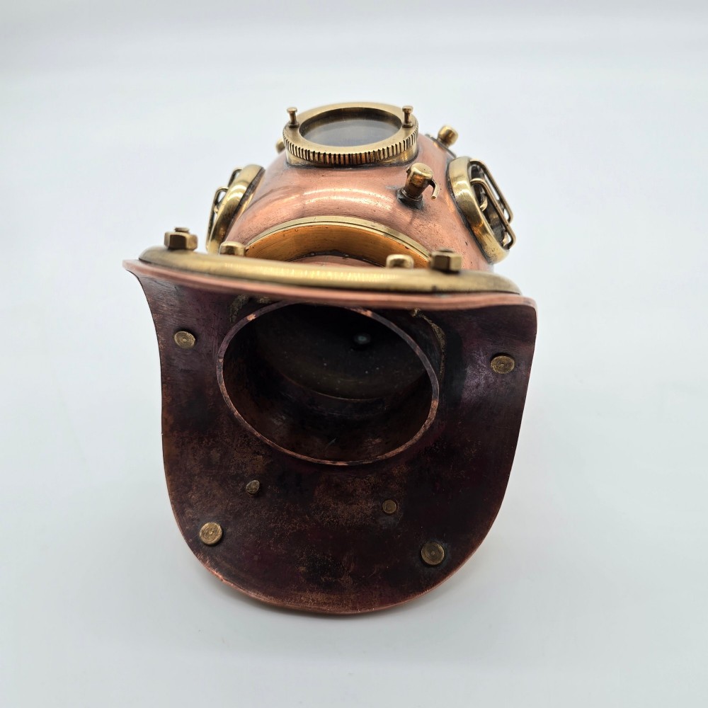 A miniature copper and brass deep-sea divers helmet featuring glass viewports, side valves, and brass shoulder plate studs on a plain white background. View IX