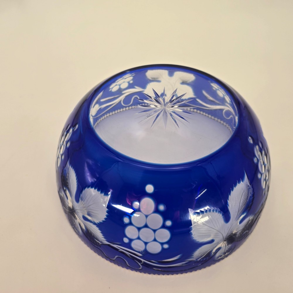 A large round Bohemian cobalt blue cut-to-clear glass bowl featuring etched grapevine leaves, grape clusters, and a serrated rim. View XIV