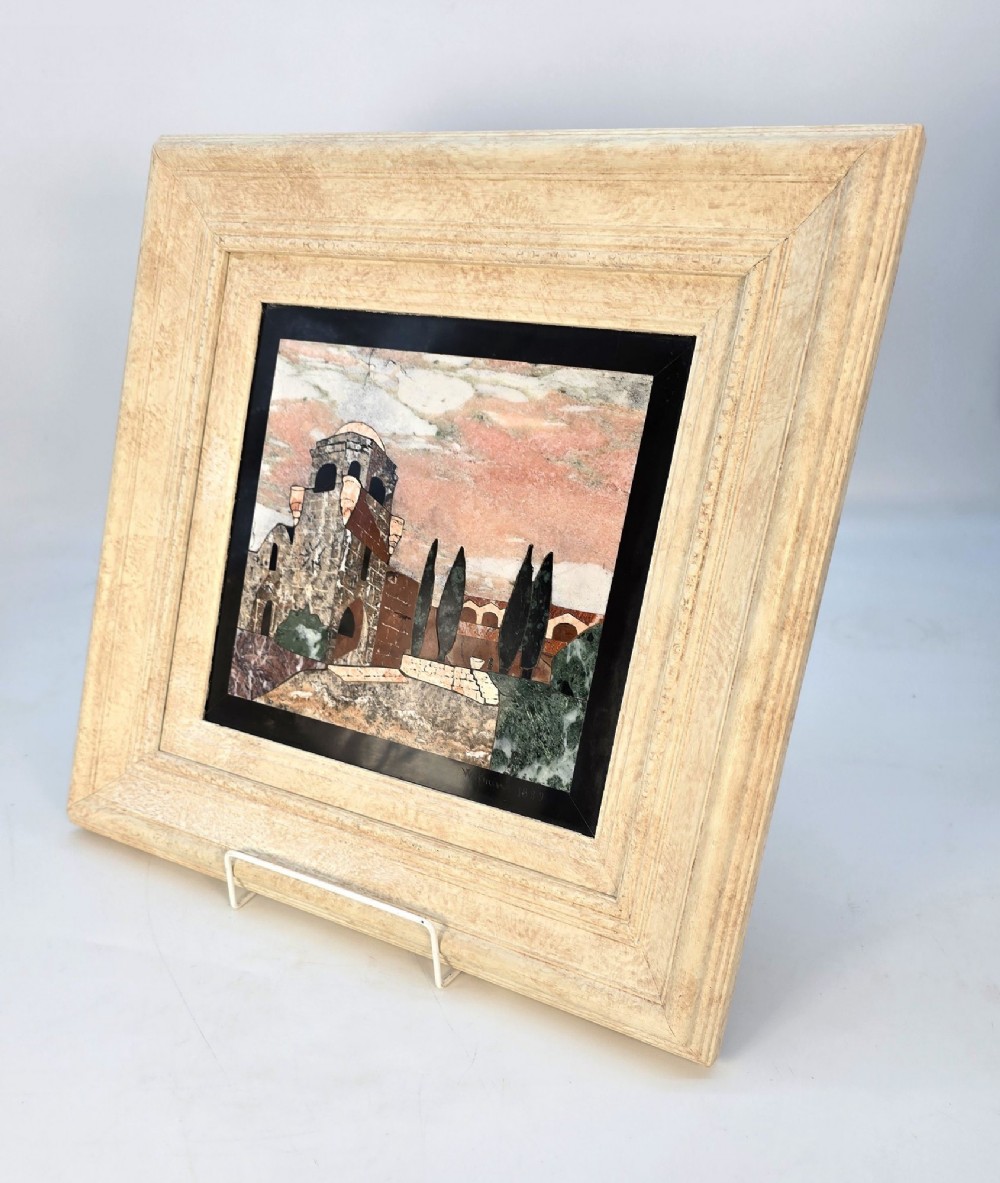 A framed Italian pietra dura panel depicting a stone building and cypress trees rendered in inlaid coloured marble. View X