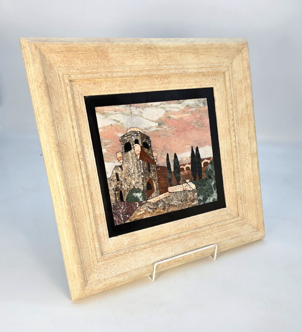 A framed Italian pietra dura panel depicting a stone building and cypress trees rendered in inlaid coloured marble. View XI